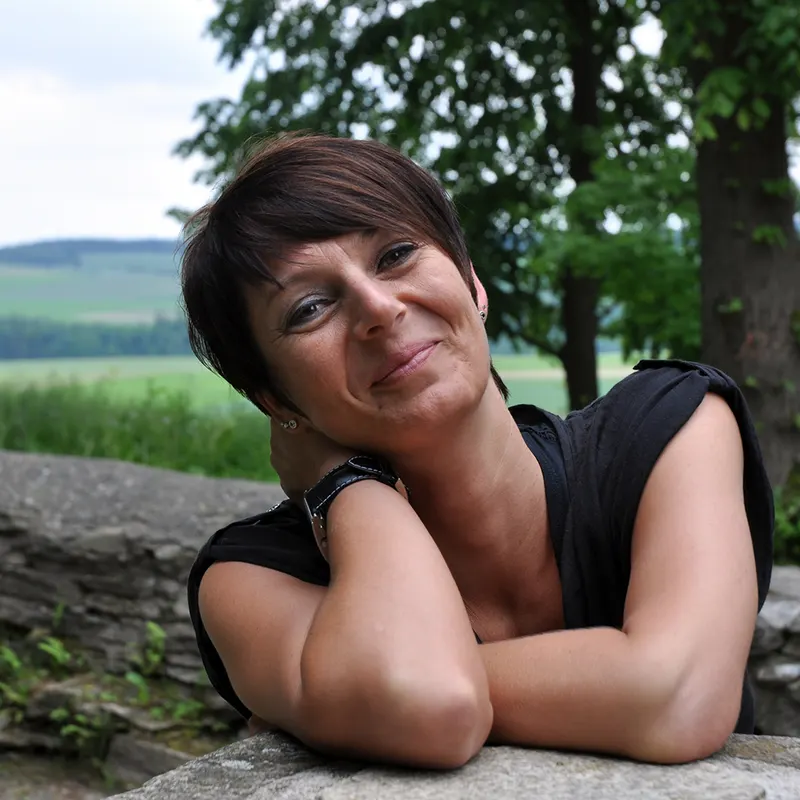 Ramona Teschner lächelt vor einer grünen Landschaft